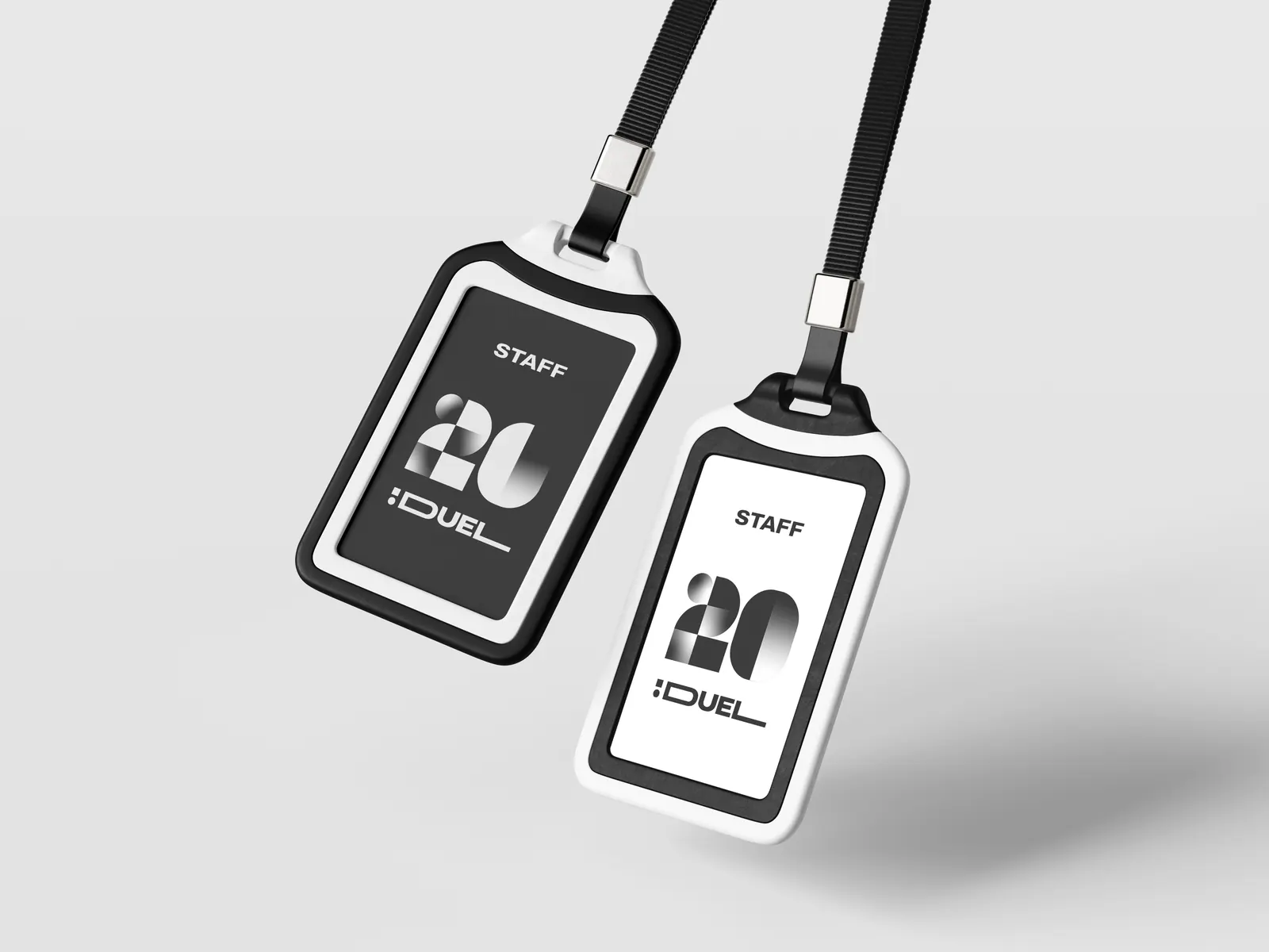 Two staff passes on lanyards, one black and one white, with the 20 logo